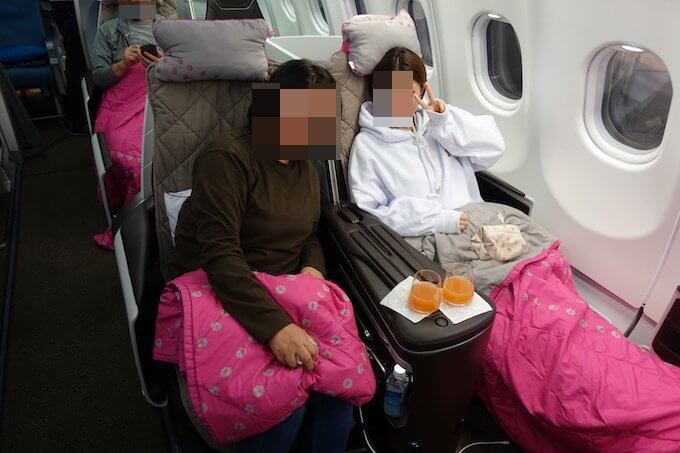 ハワイアン航空のビジネスクラスで喜ぶ家族の写真